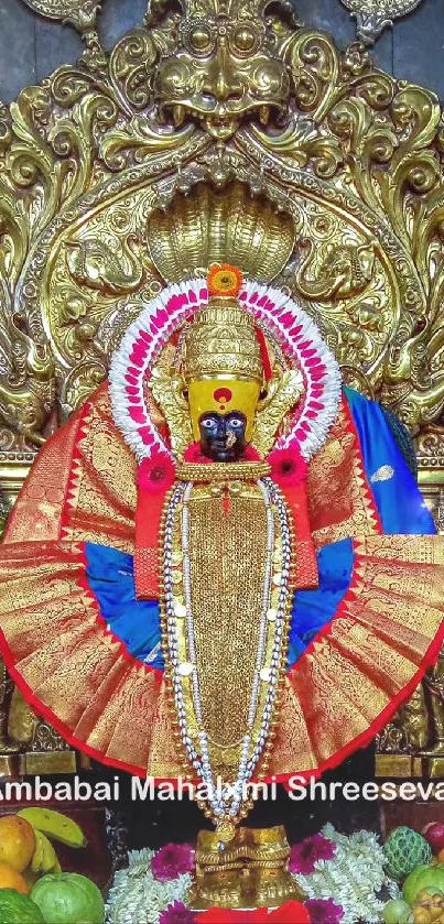 Golden deity adorned in colorful garments in ornate shrine.