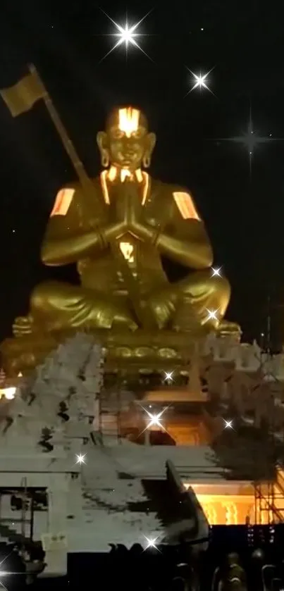 Golden statue under a starry sky at night, illuminated and serene.