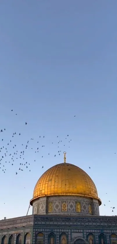 Golden dome with birds flying in a blue sky.