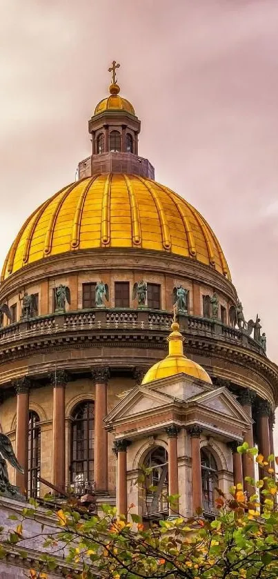 Golden dome cathedral surrounded by green foliage.