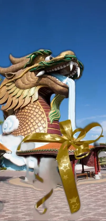 Golden dragon sculpture against a blue sky with decorative ribbon.