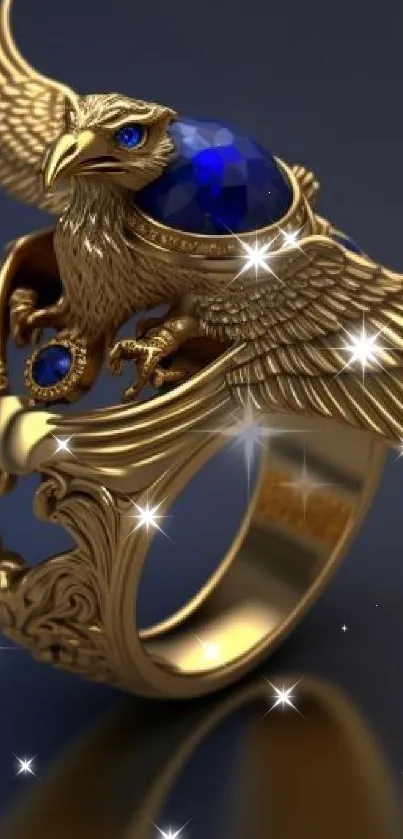 Elegant golden eagle ring with blue sapphire on dark background.