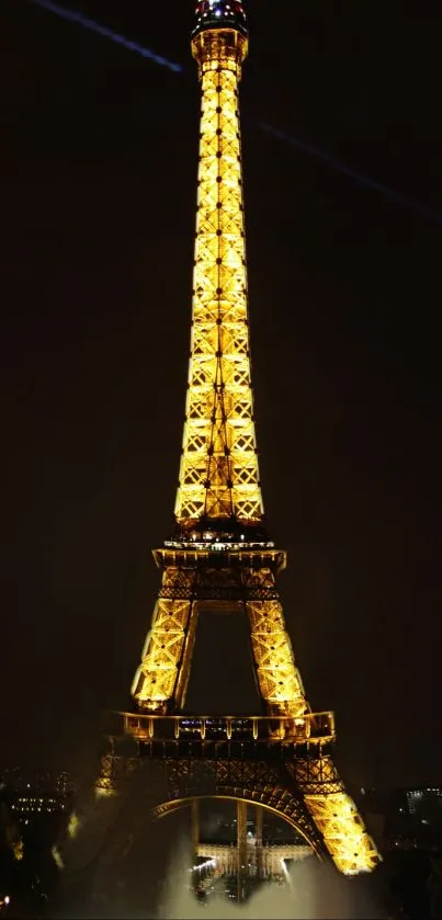 Eiffel Tower glowing in gold at night, stunning mobile wallpaper.