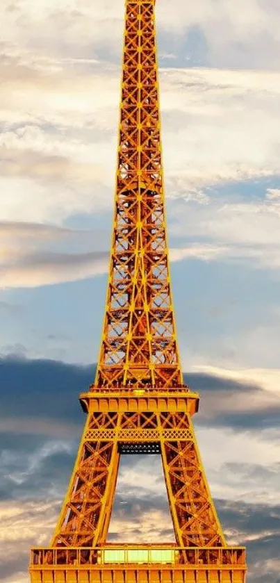 Eiffel Tower glowing golden at sunset set against a dramatic sky.