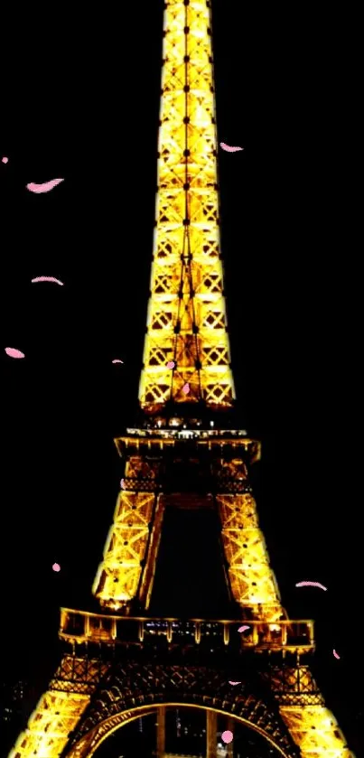 Golden Eiffel Tower against night sky with pink petals falling.