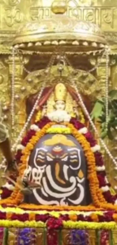 Gold-adorned Ganesha idol with flowers.