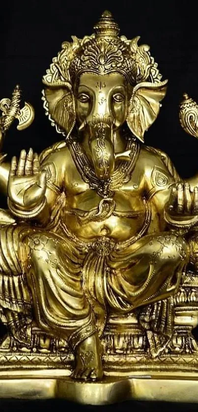 Golden Ganesha statue on black background wallpaper.