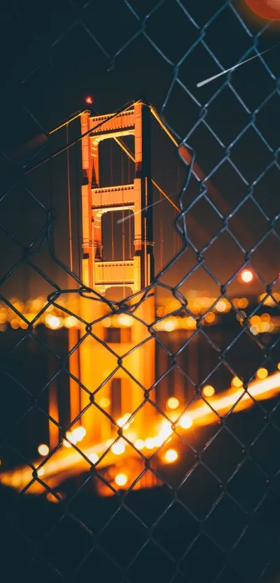 Golden Gate Bridge beautifully lit at night through a wire fence.