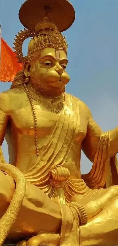 Golden Hanuman statue against blue sky.