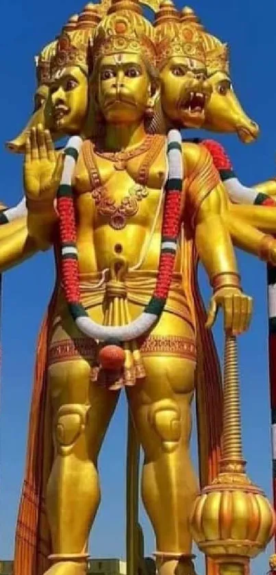 Golden Hanuman statue under a blue sky, showcasing vibrant colors and spirituality.