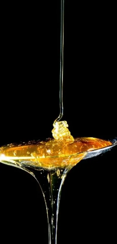 Mobile wallpaper with golden honey dripping from a spoon on black background.