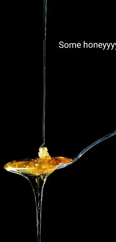 Golden honey drips off a spoon on a sleek black background.