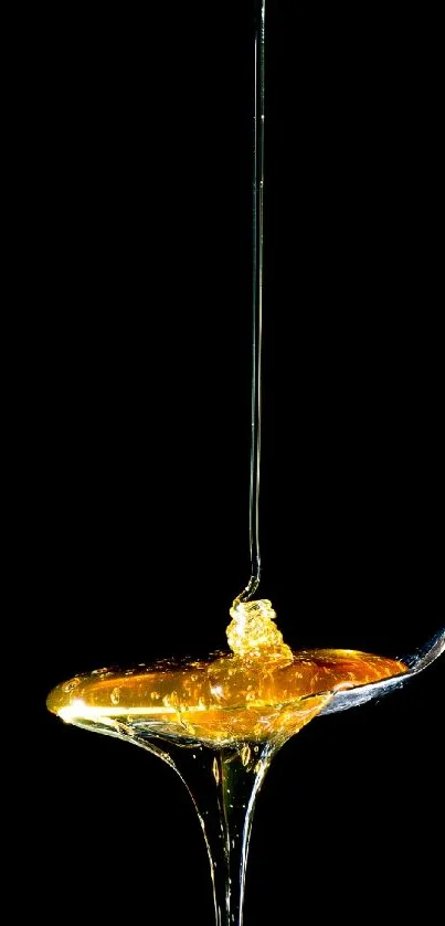 Golden honey dripping from spoon on black.