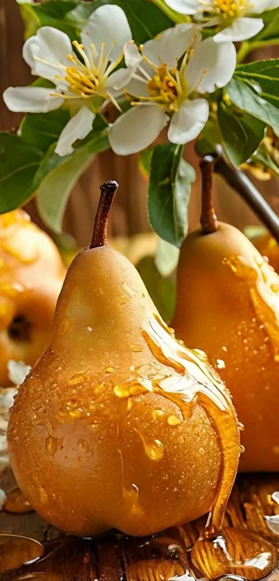 Golden pears with water droplets and blossoms on a wooden surface.