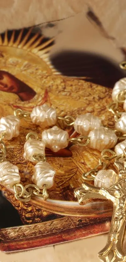 Golden religious icon with rosary beads on a wooden background.