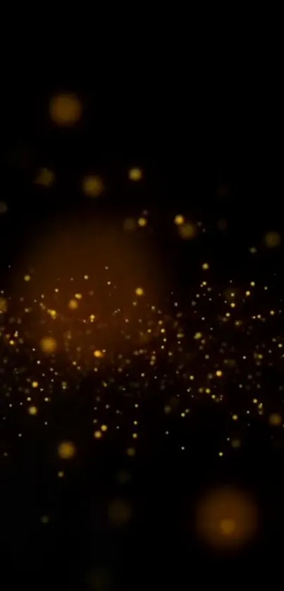 Golden sparkles on a dark abstract wallpaper background.