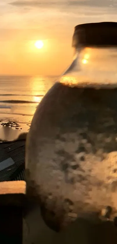 Golden sunset over a beach with soft focus bottle in foreground.