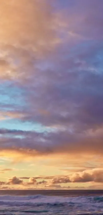 Golden sunset over ocean with pink clouds and blue sky.