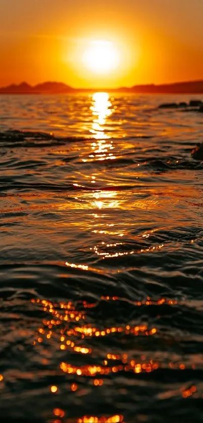 Golden sunset over ocean waves with a vibrant sky reflection.