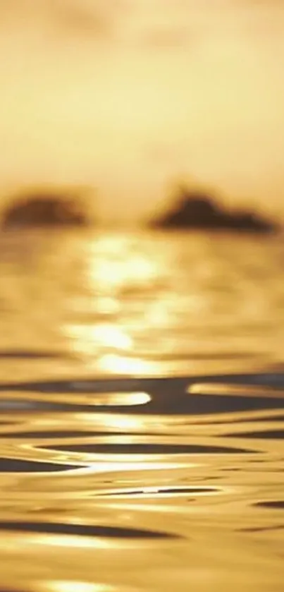 Golden sunset over ocean with rippling waves.