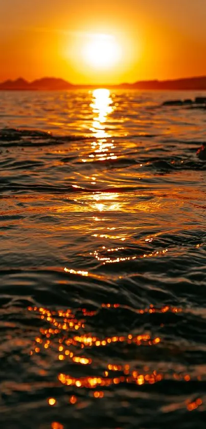 Vibrant golden sunset reflecting on calm ocean waves.