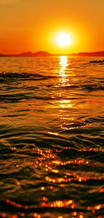 Golden sunset over the ocean with shimmering waves, ideal for mobile wallpaper.