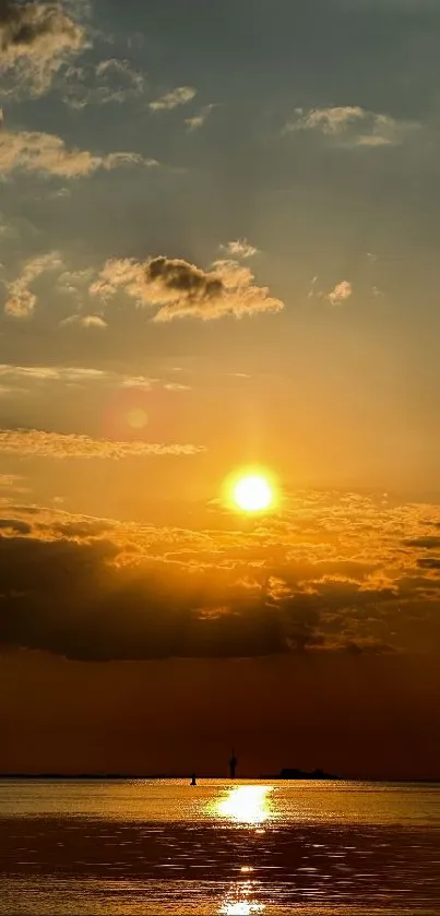 Golden sunset over ocean with glowing reflections and serene sky.