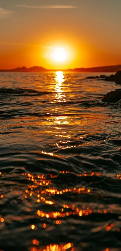 Golden sunset over ocean with shimmering reflections.