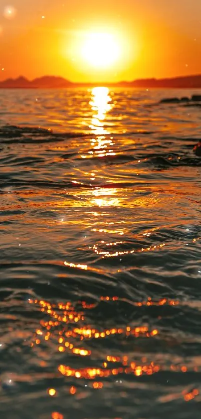 Golden sunset casting reflections over ocean waves.