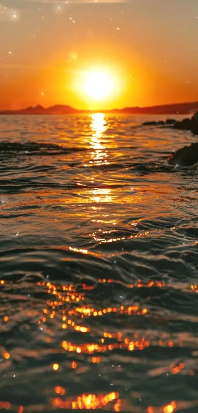 Golden sunset over ocean waves creating a serene mobile wallpaper.