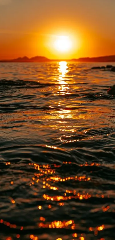 Golden sunset reflecting over ocean waves for mobile wallpaper.