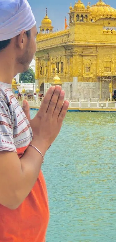 Man praying at the Golden Temple with serene landscape.