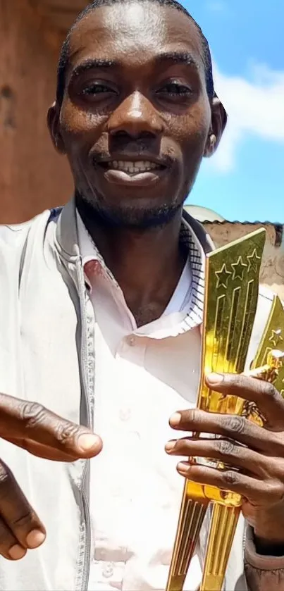 Person holding a golden trophy with blue sky in the background wallpaper.