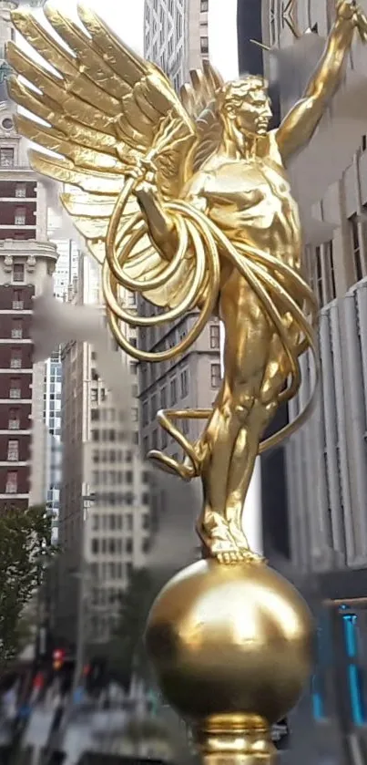 Golden winged statue with cityscape background in urban setting.