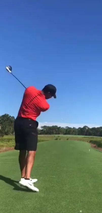 Golfer swings on a clear day against a vibrant blue sky and green fairway.