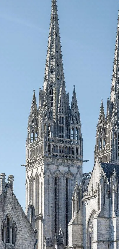 Gothic cathedral spires against blue sky, showcasing architectural beauty.