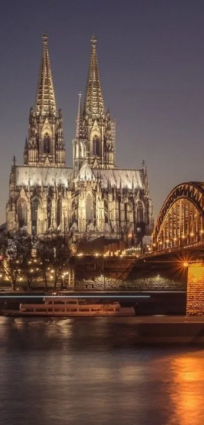 Illuminated Gothic cathedral with river reflection at night.