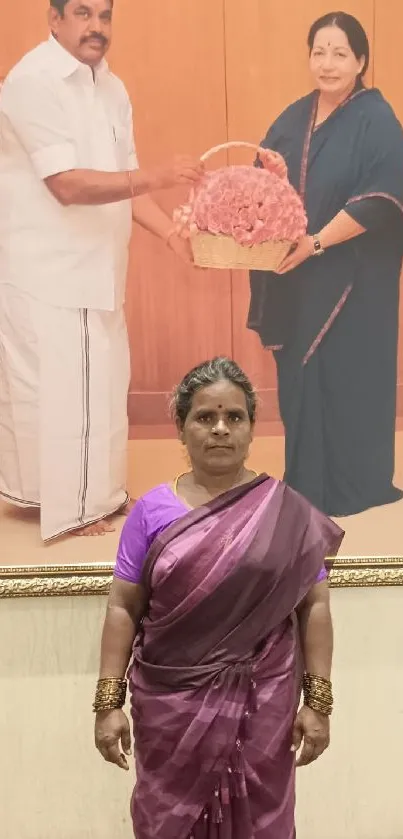 Woman in purple sari with framed photograph background.