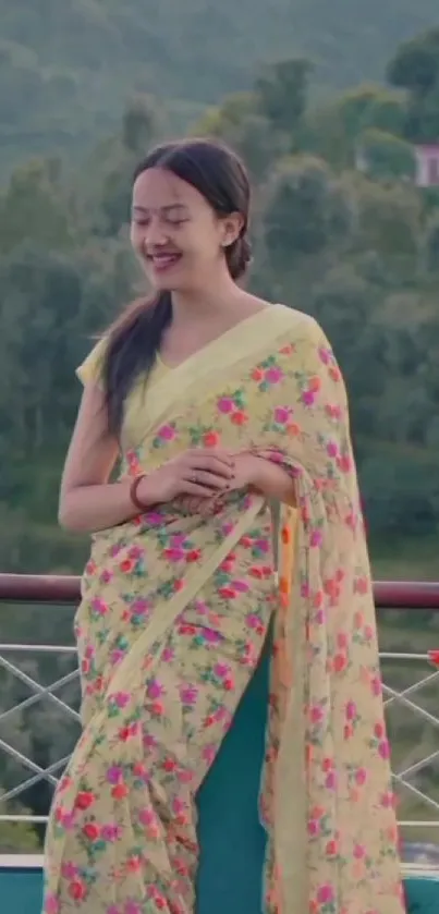 Woman in floral saree with lush green background.