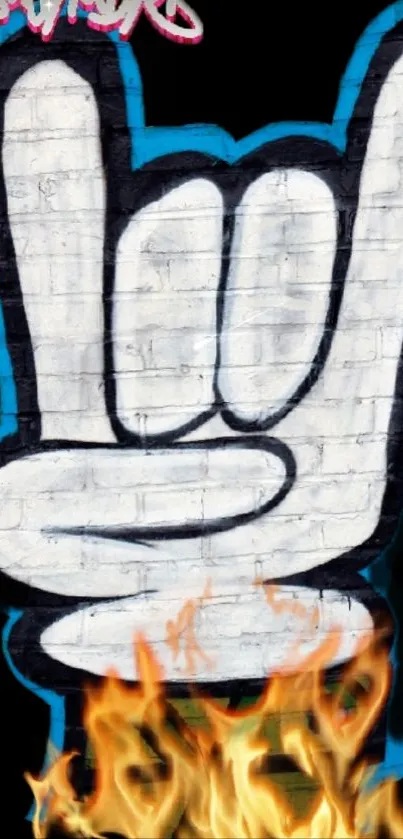 Graffiti rock hand on brick with flames.