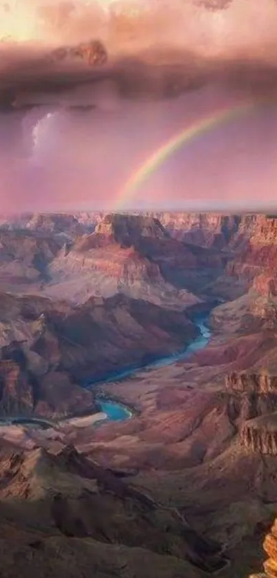 A majestic view of a canyon with a vibrant rainbow in the sky.