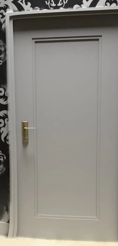 Gray door against black and white patterned wallpaper