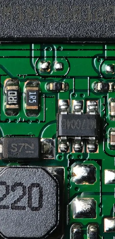 Closeup of a green circuit board showing electronic components and pathways.