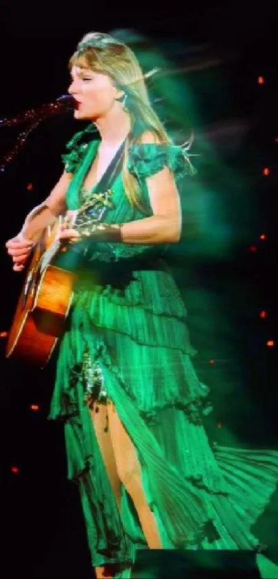 Vibrant green dressed performer on stage with guitar under dynamic lights.