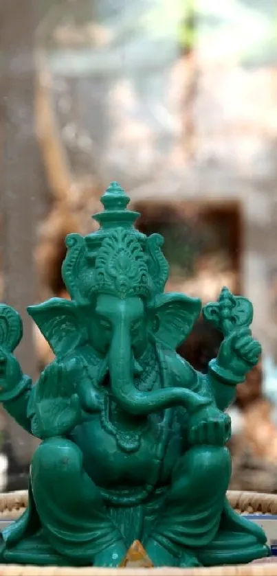 Green Ganesha statue on a serene blurred background.