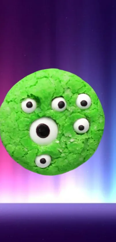 Green cookie with monster eyes on colorful gradient background.