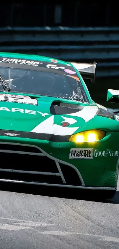 Green race car speeding on a track during daytime.