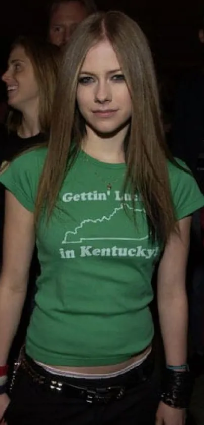 Young woman in green shirt in a crowd.