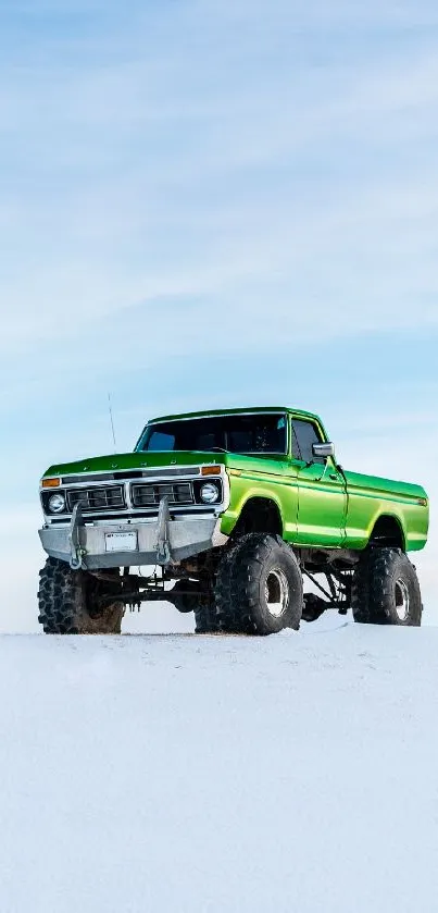 Green truck on snowy landscape under a bright blue sky.