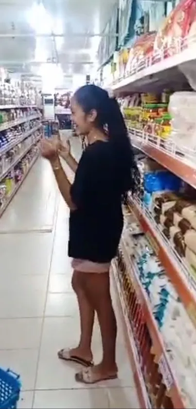 Woman shopping in grocery aisle with stocked shelves.